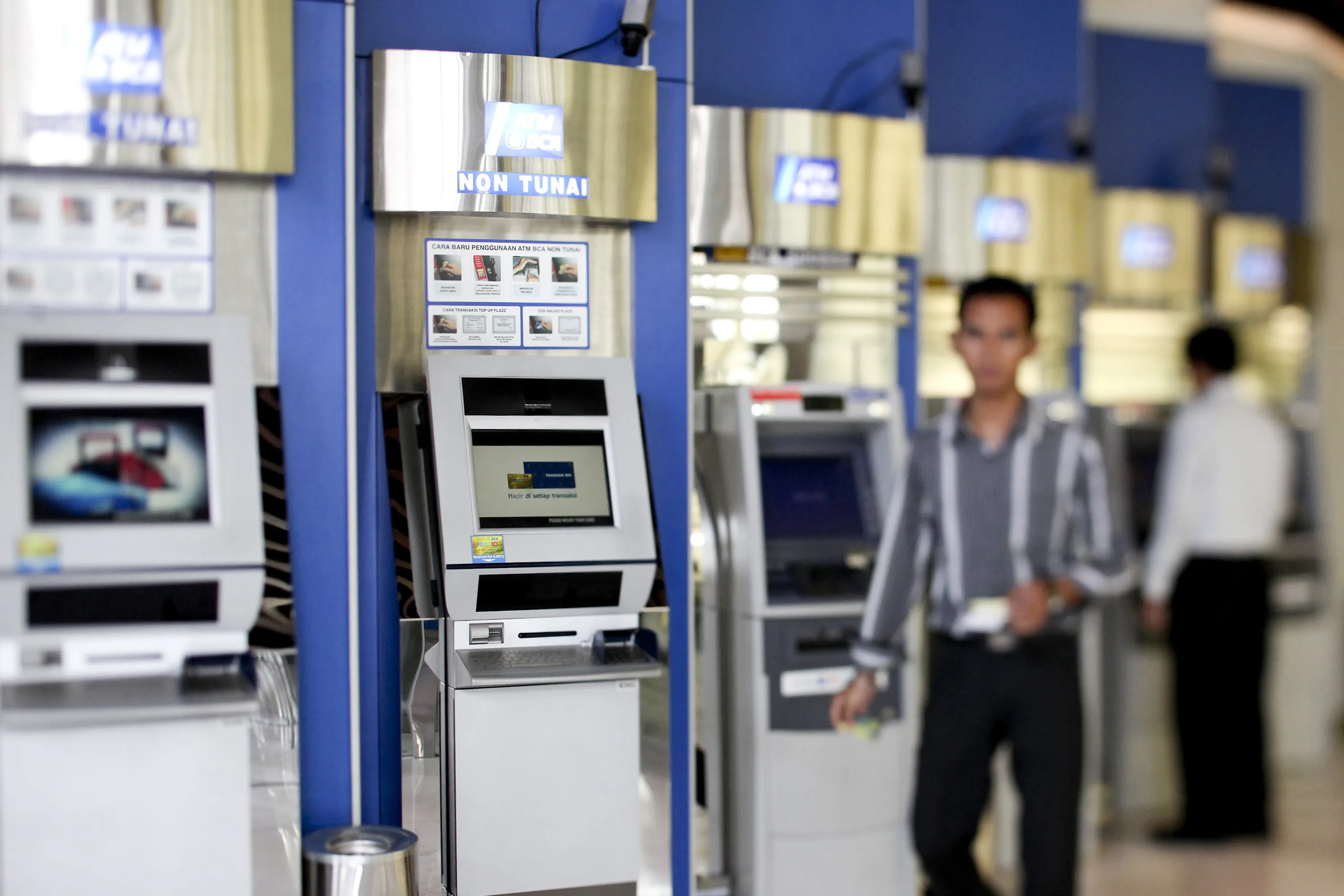 A man walks past&nbsp;bank ATM, photographed with a tilt-shift lens, at the company's headquarters in Jakarta, Indonesia on Wednesday, July 27, 2011.&nbsp;