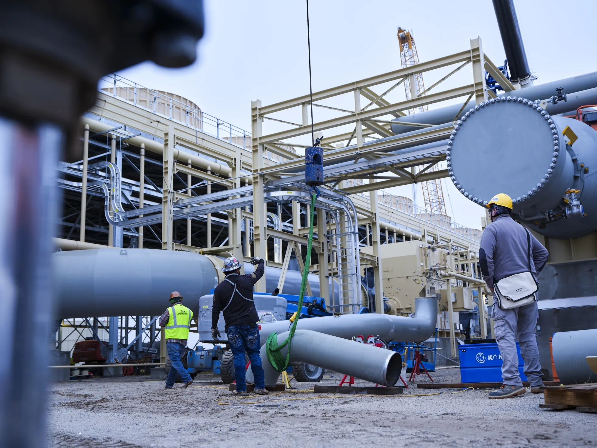Workers installing geothermal power production equipment.