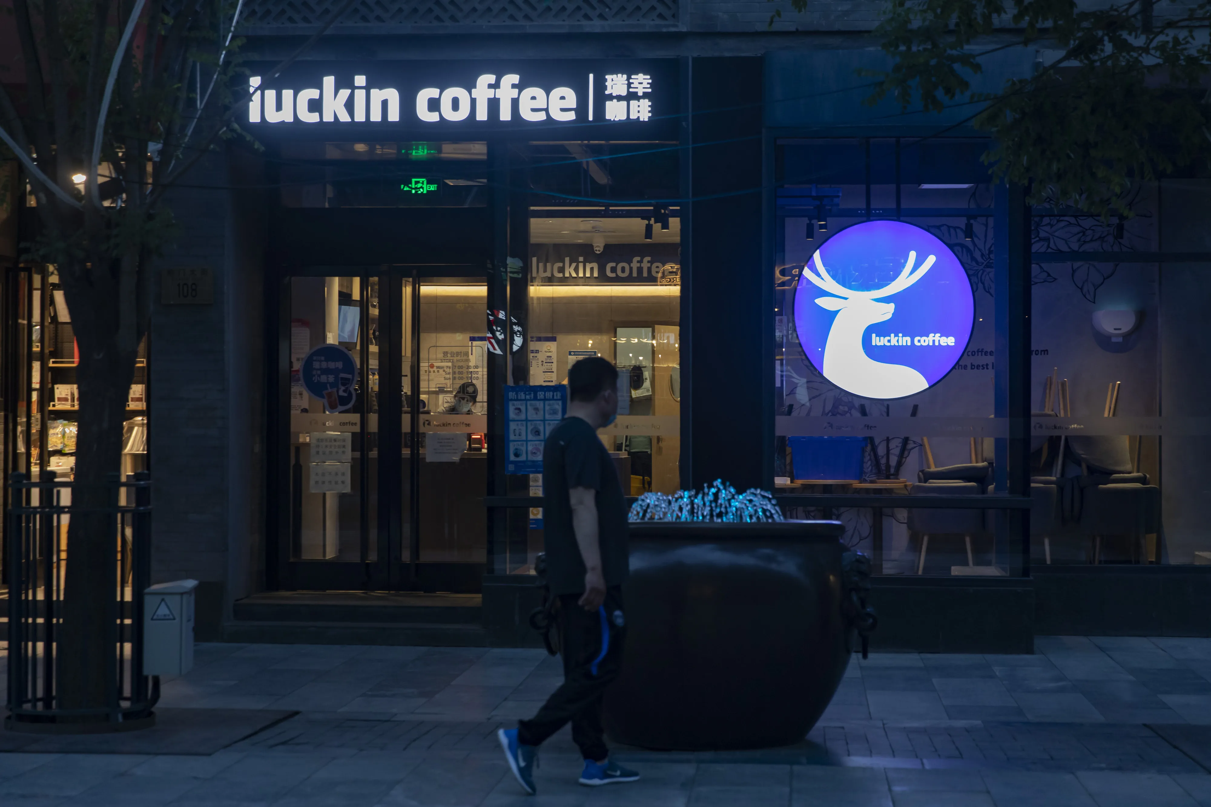 A pedestrian&nbsp;walks past a Luckin Coffee outlet in the Qianmen area of Beijing.