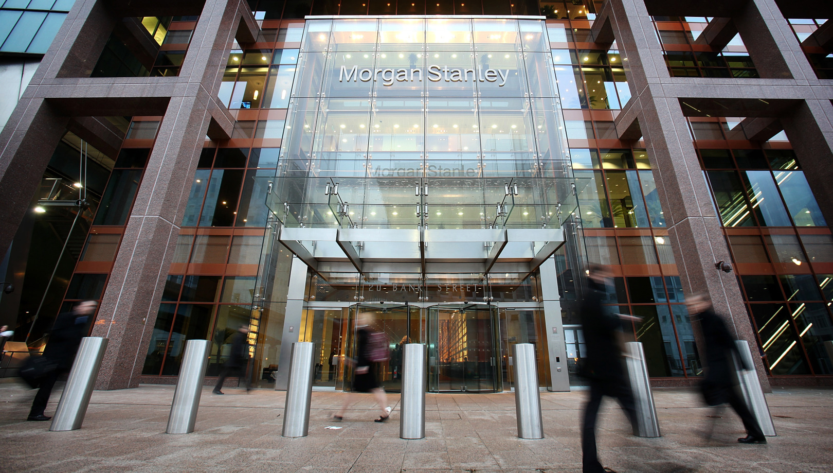 Pedestrians pass the Morgan Stanley headquarters at Canary Wharf in London.