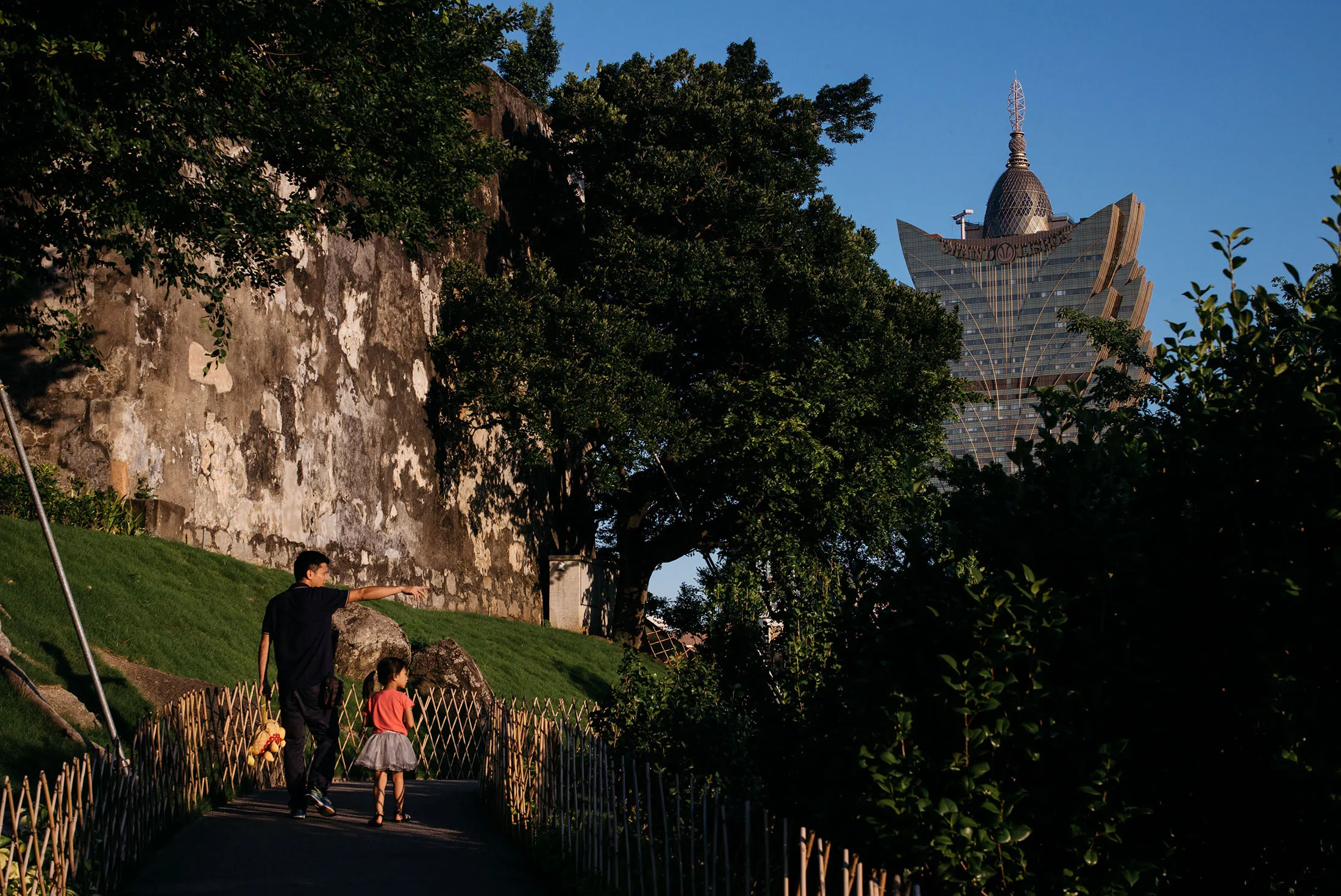 A man and a child walk on a path at a park near Fortaleza do Monte in Macau. Macau reversed its 26-month slump in gaming revenue in August.
