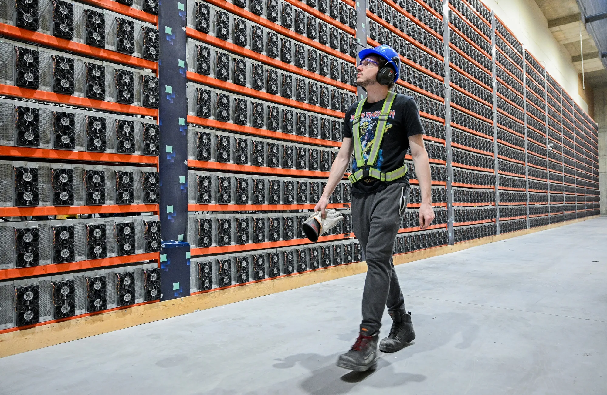 A technician walks near cryptocurrency mining rigs at the Bitfarms Bunker facility in Sherbrooke, Quebec, Canada, on Monday, Sept. 9, 2024.