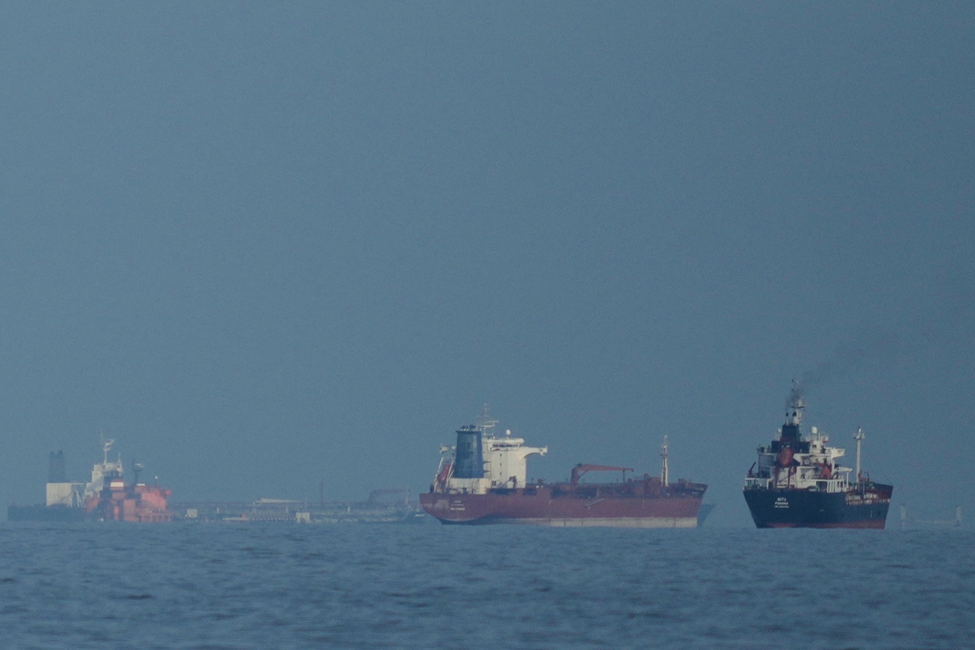 Ships line up in the Strait of Hormuz as seen from Khor Fakkan, United Arab Emirates, on March 11.