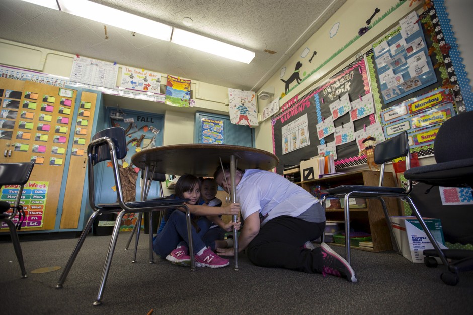 A teacher and students practice the drop, cover, and hold on technique during the &quot;Great ShakeOut&quot; earthquake drill at Marlton School in Los Angeles, California.