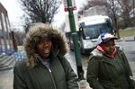 A pair of students walk to a bus after school at Excel Academy in Baltimore in March 2018. About 13,000 high-schoolers in the city rely on public transportation to get to school.