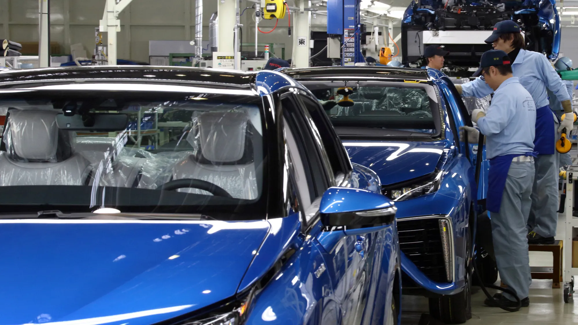 Toyota Motor Corp. workers assemble a Mirai fuel-cell vehicle on the production line of the company's Motomachi plant in Toyota, Aichi Prefecture, Japan, on Tuesday, Feb. 24, 2015. President Akio Toyoda was at the factory to formally mark the roll out of a car named after the Japanese word for 'future.' The Mirai, selling for 7.24 million yen, represents Toyota's bet that the emissions-free cars of the future will run on hydrogen.
