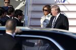 U.S. President Donald Trump, right, and First Lady Melania Trump, second right, are greeted by Taro Kono, Japan's foreign minister, after disembarking from Air Force One as they arrive at Haneda Airport in Tokyo.