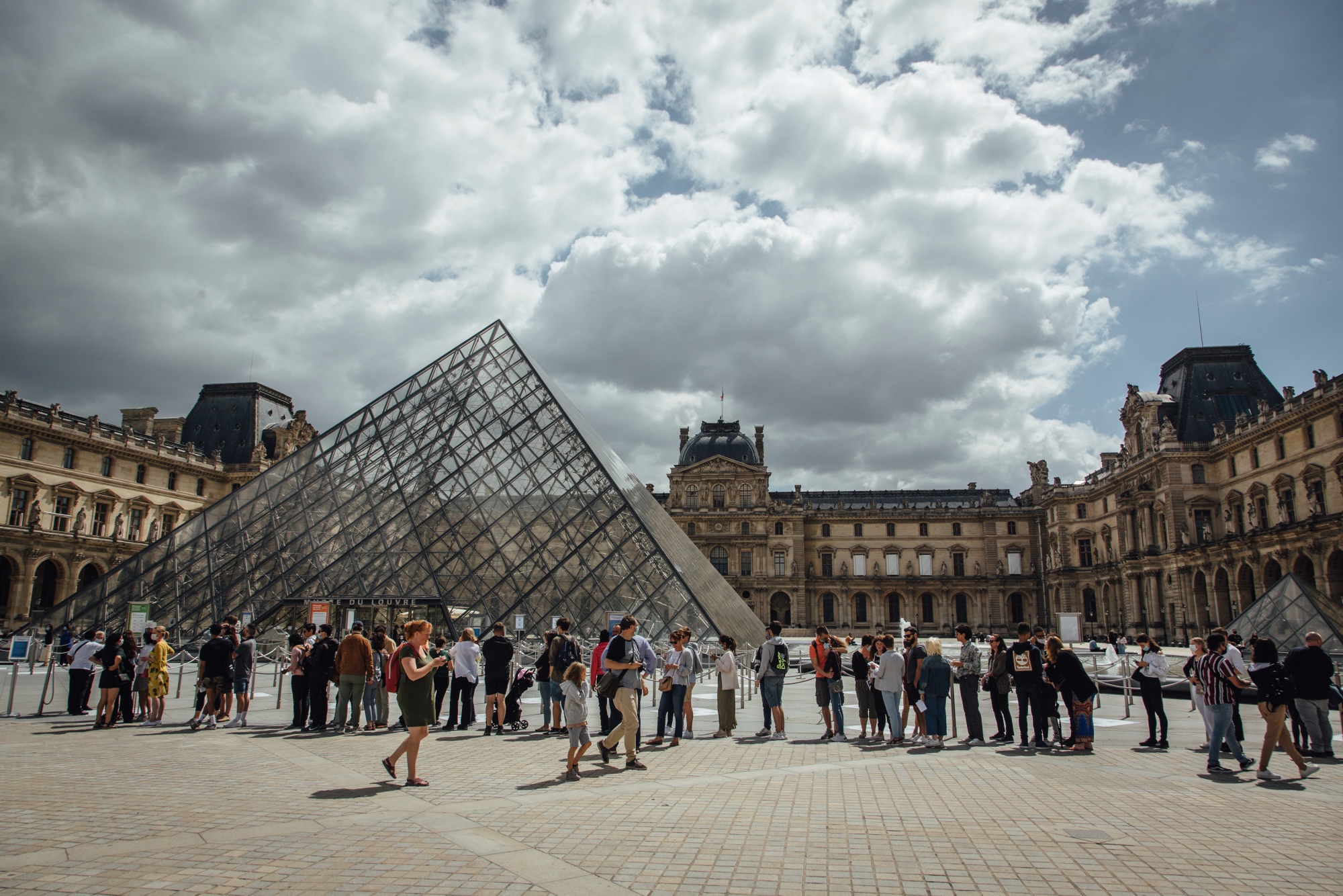 Visitors queue to enter the reopened Louvre Museum in Paris on July 6.