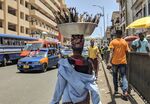 A street vendor carries a container of smoked fish on her head in Accra.