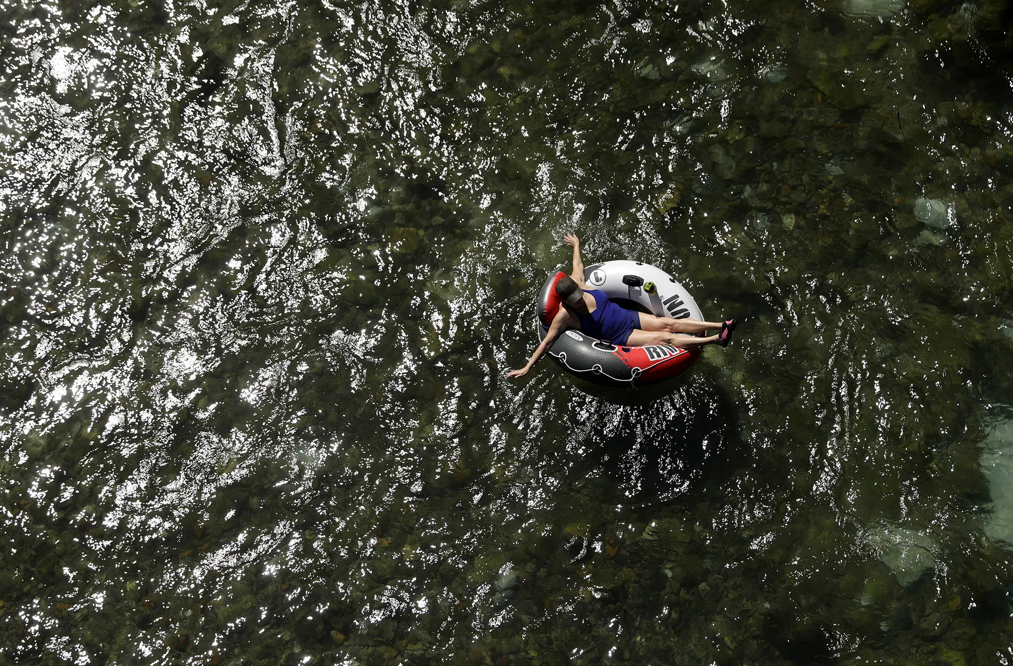 Beating the heat, a tuber floats the&nbsp;Comal River&nbsp;in New Braunfels, Texas.&nbsp;