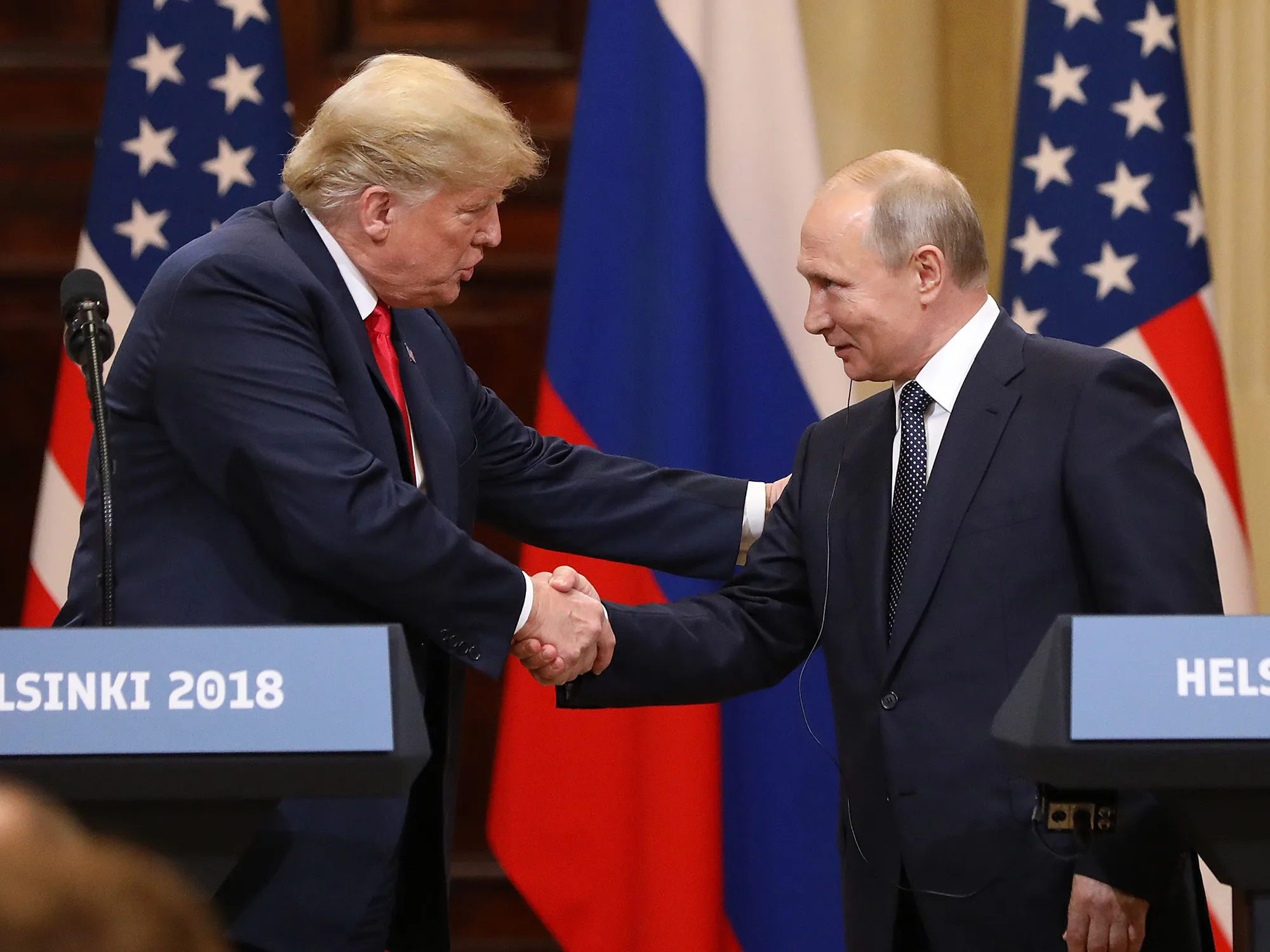 Trump, left, shakes hands with Putin during a news conference in Helsinki on July 16, 2018.&nbsp;