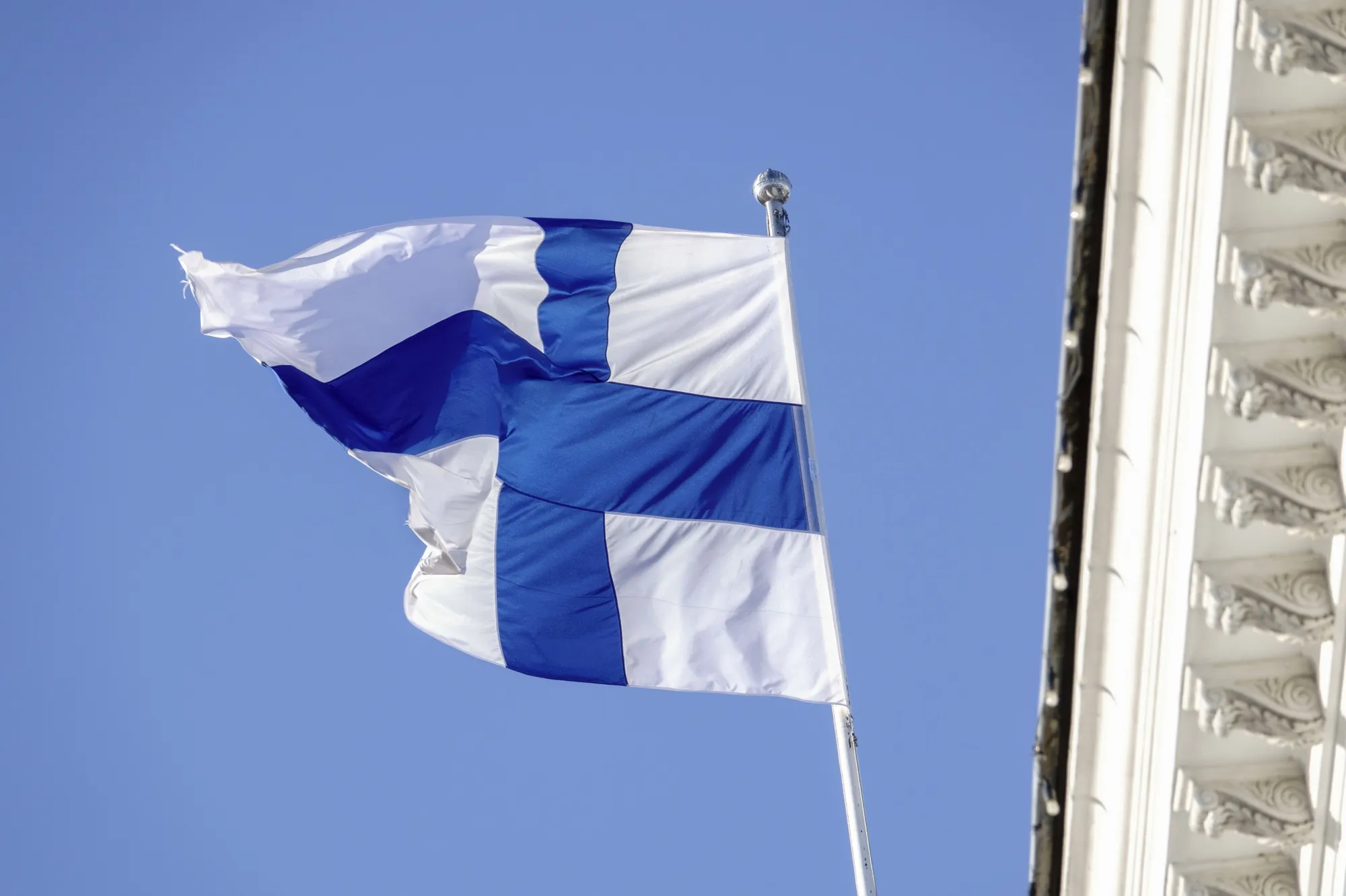 A Finnish national flag at the City Hall building in Helsinki, Finland.