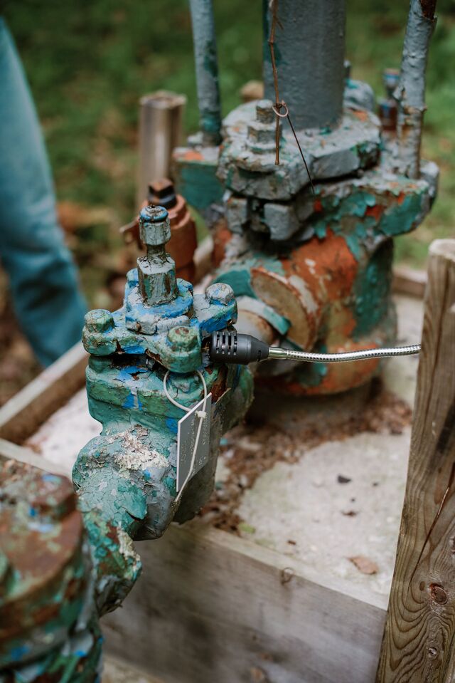 Inspecting a Diversified natural gas well with a hand-held sniffer in West Virginia. 
