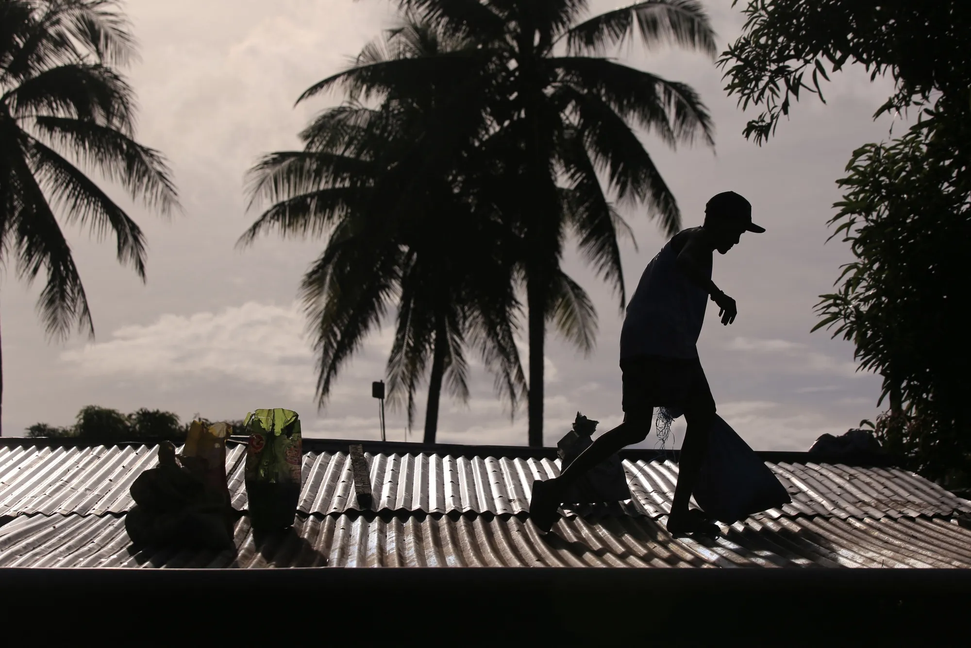 A resident secures the roof of a house ahead of the landfall of Typhoon Man-Yi, in Legazpi, Albay on Nov. 15.