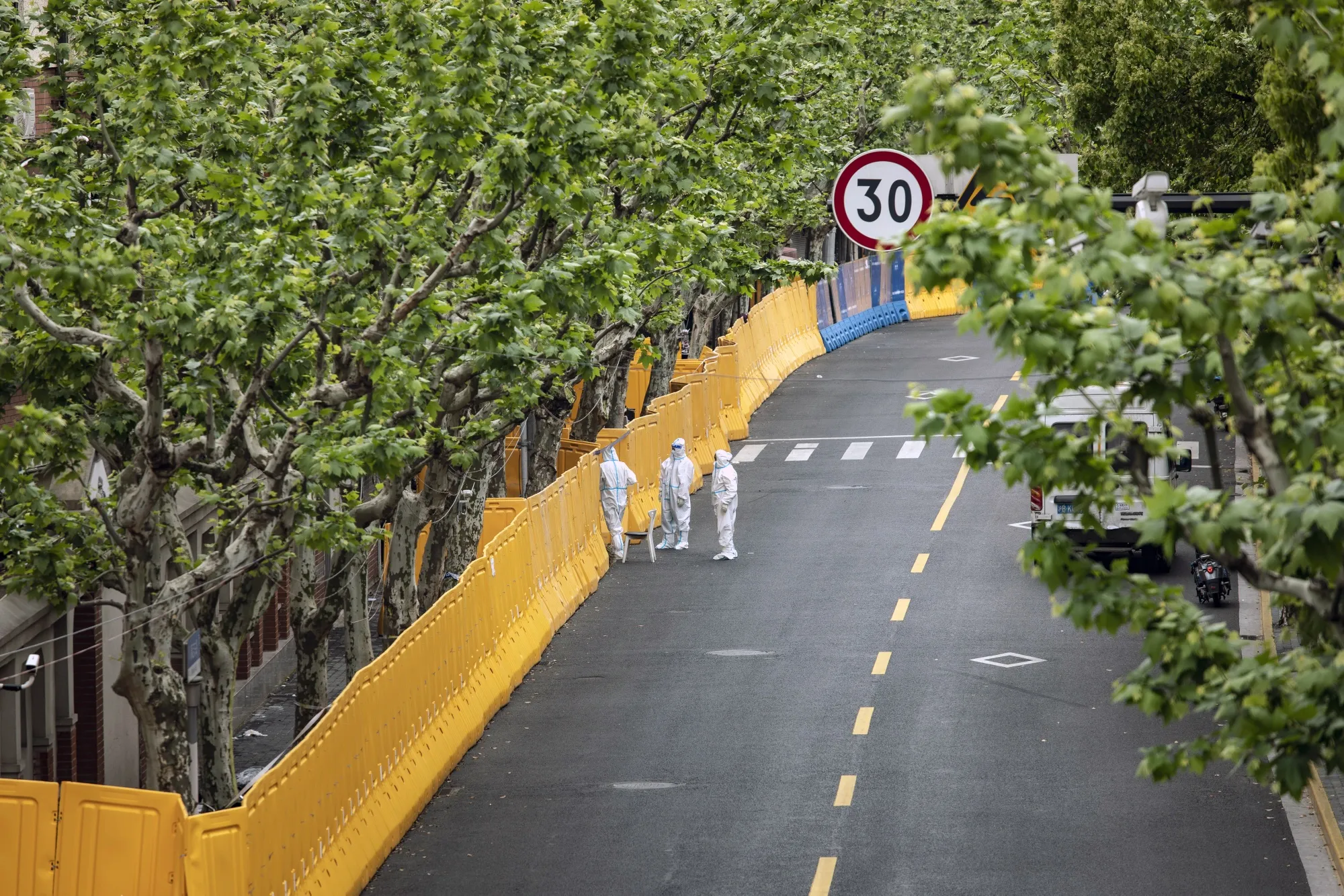 Workers in personal protective equipment&nbsp;stand next to barriers during a lockdown due to Covid-19 in Shanghai, China, on April 25.