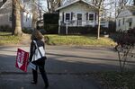 A real estate agent removes an 'Open House' sign in Columbus, Ohio, on Dec. 3, 2017.