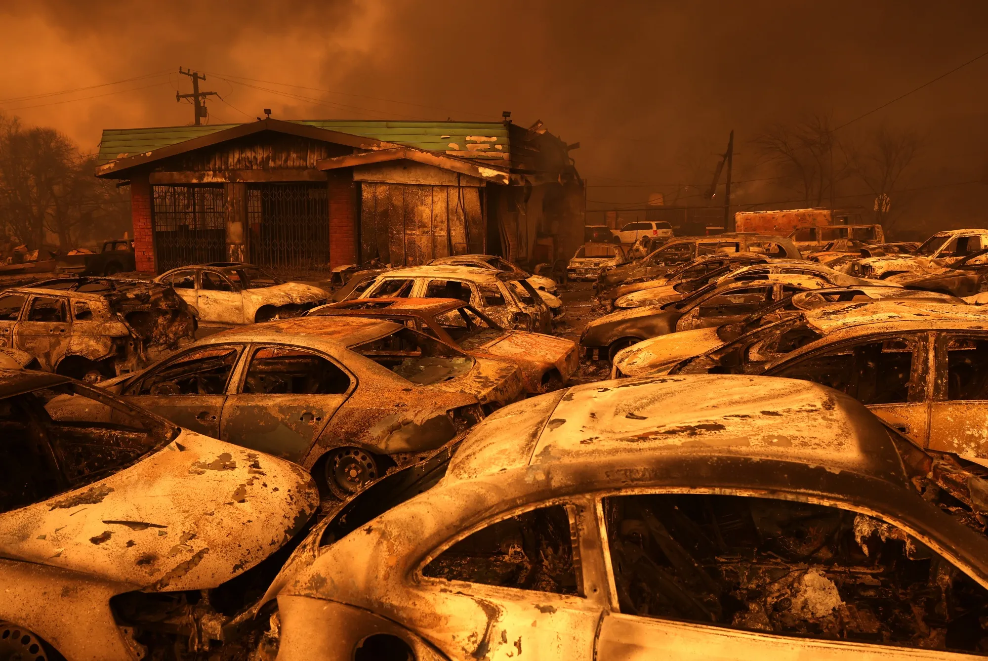 Cars destroyed by the Eaton Fire sit at a burned auto shop in Altadena, California, on Jan. 8.