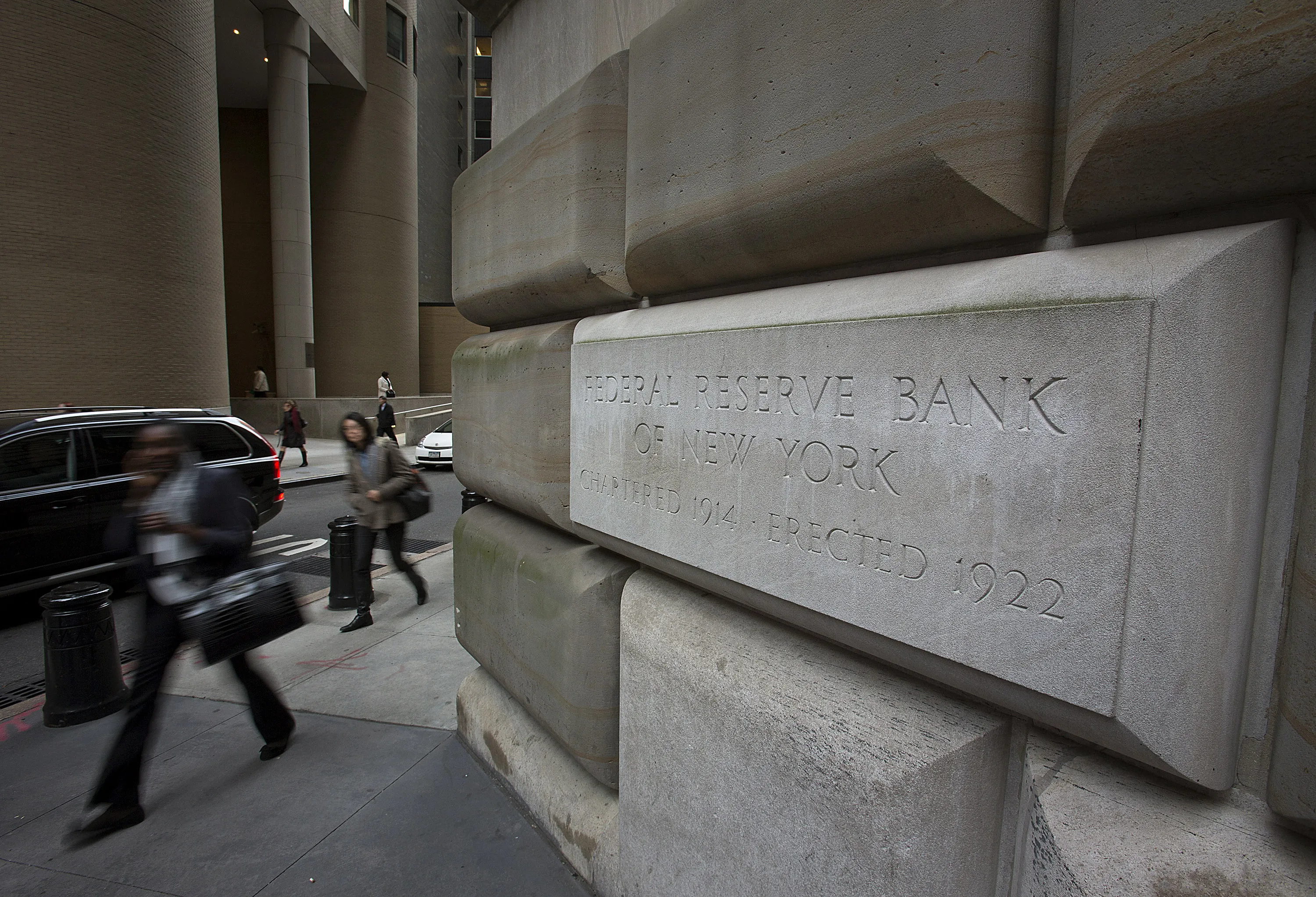 Pedestrians walk past the Federal Reserve Bank building in New York, U.S., on , Wednesday, Oct. 17, 2012.
