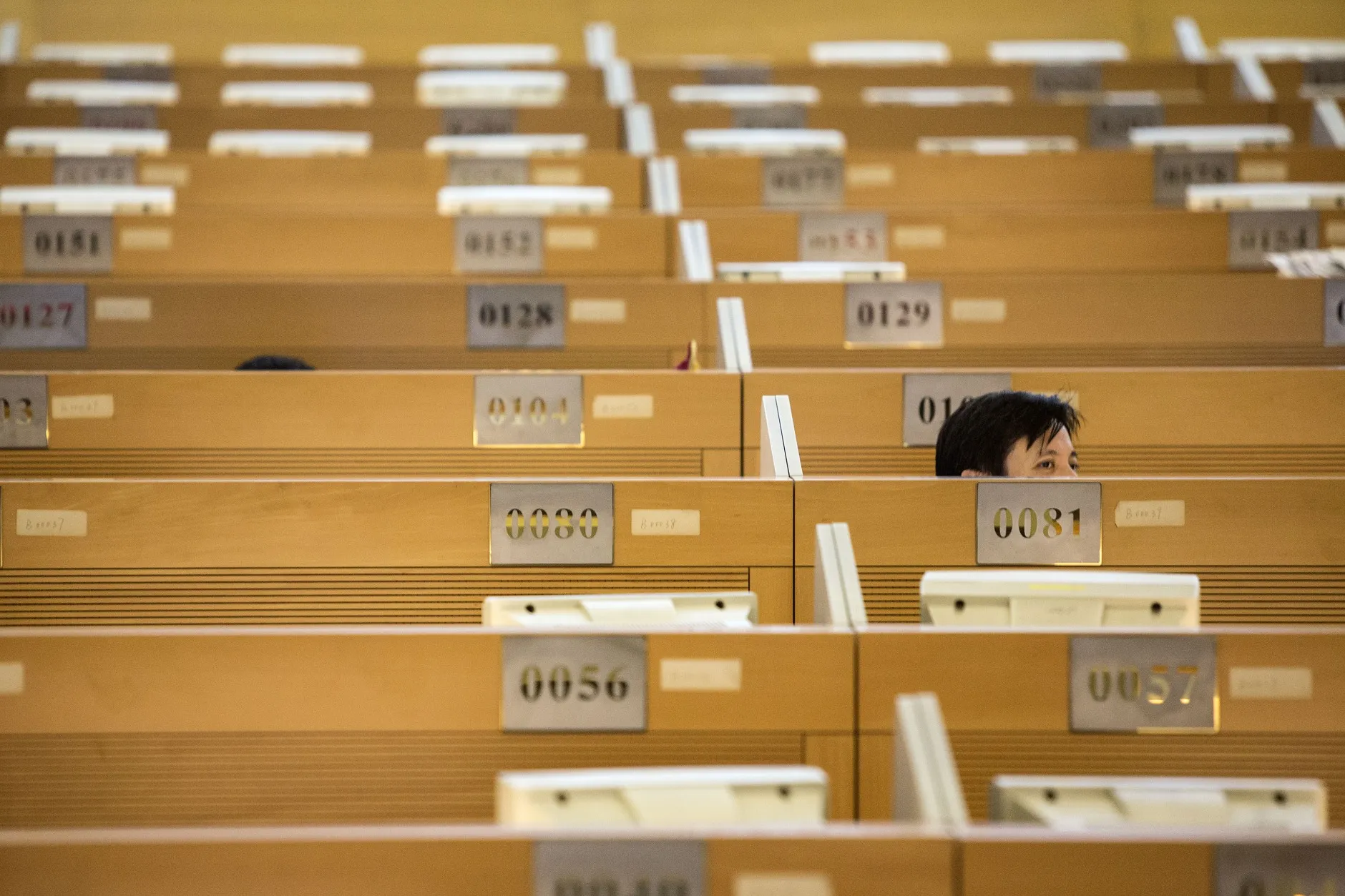 A trader looks up from a work station at the Shanghai Stock Exchange in Shanghai, China.