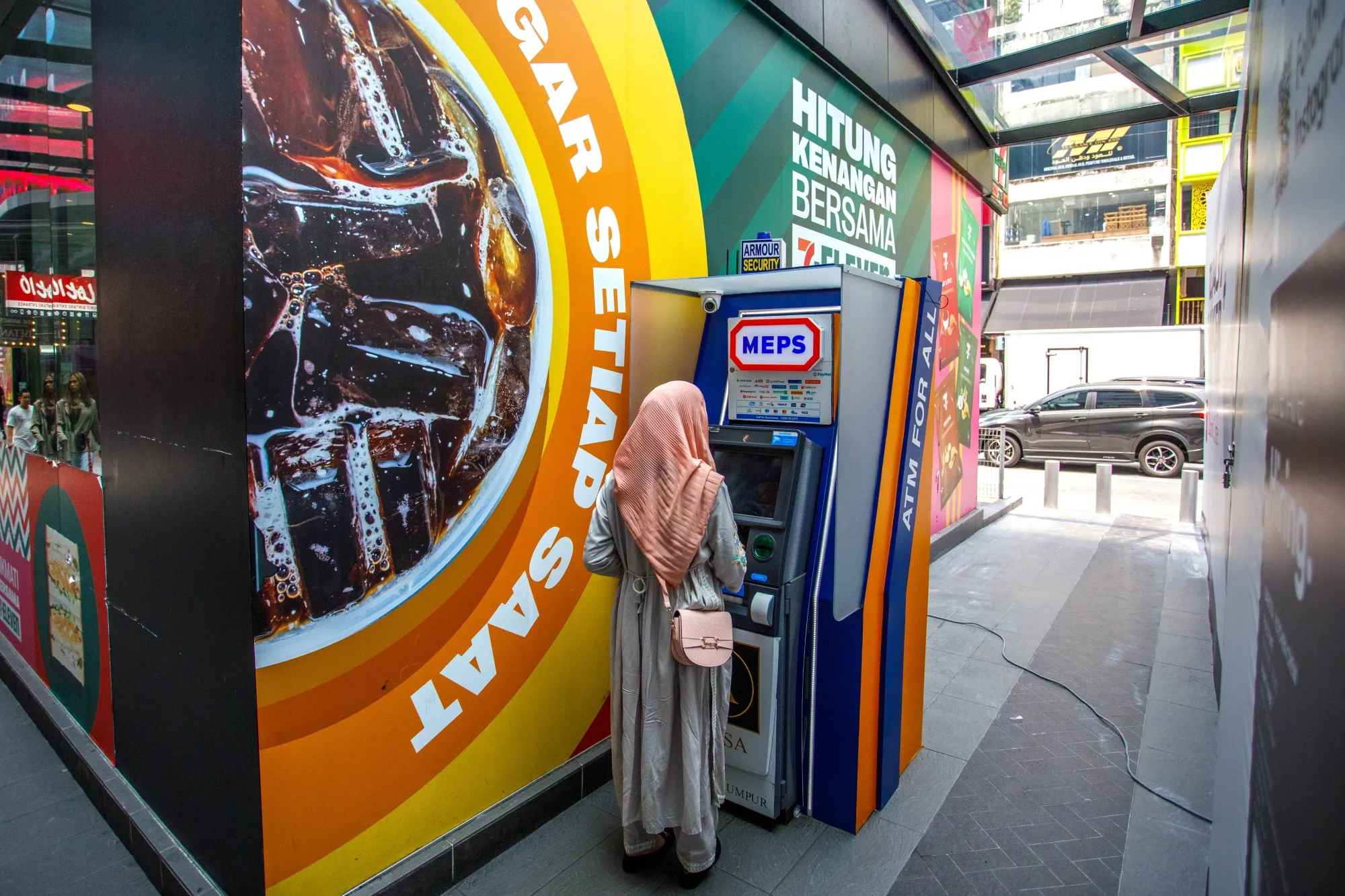 A customer uses an ATM in Kuala Lumpur.