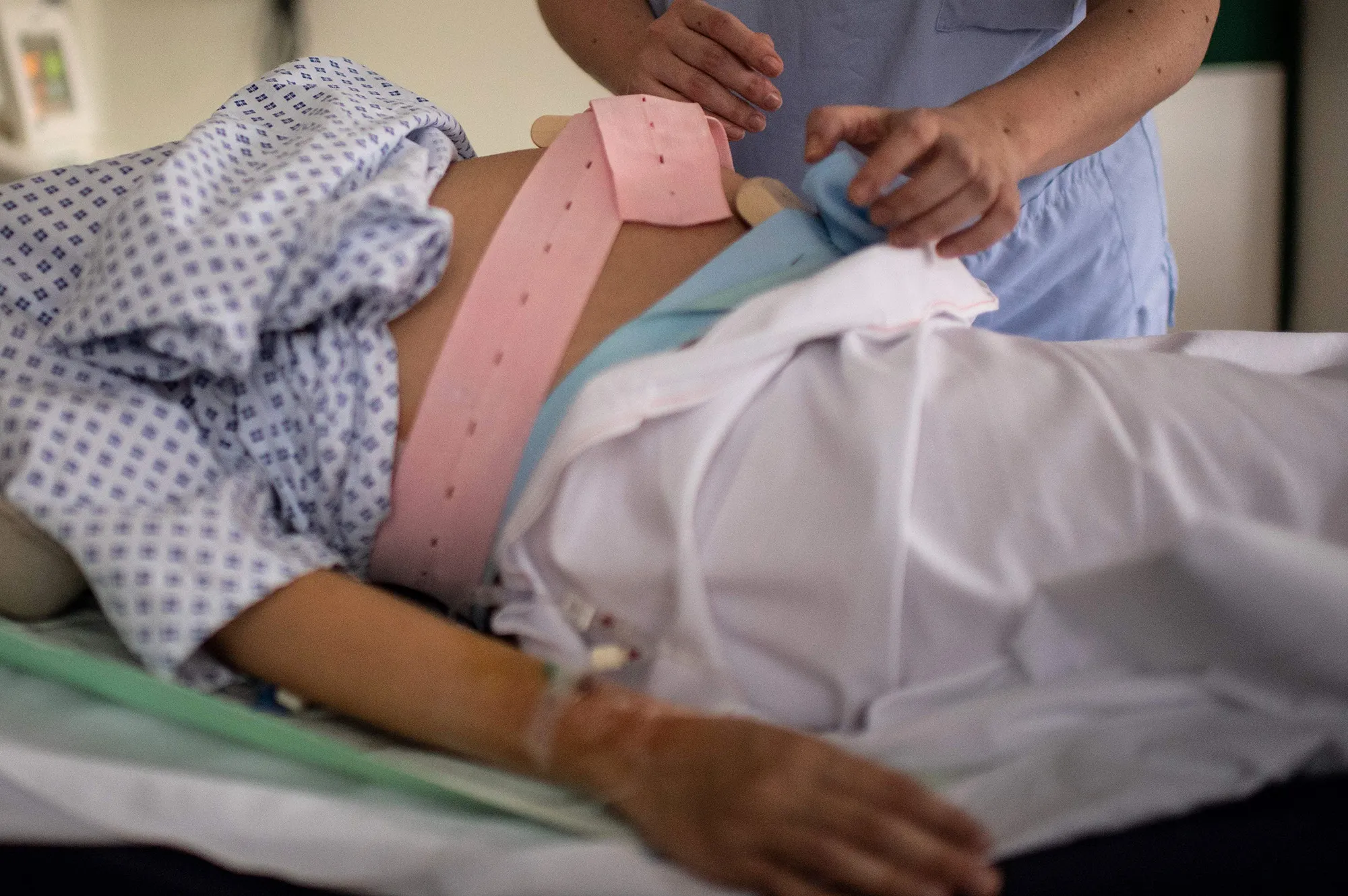 A nurse helps a pregnant woman at the maternity of a hospital in Paris.