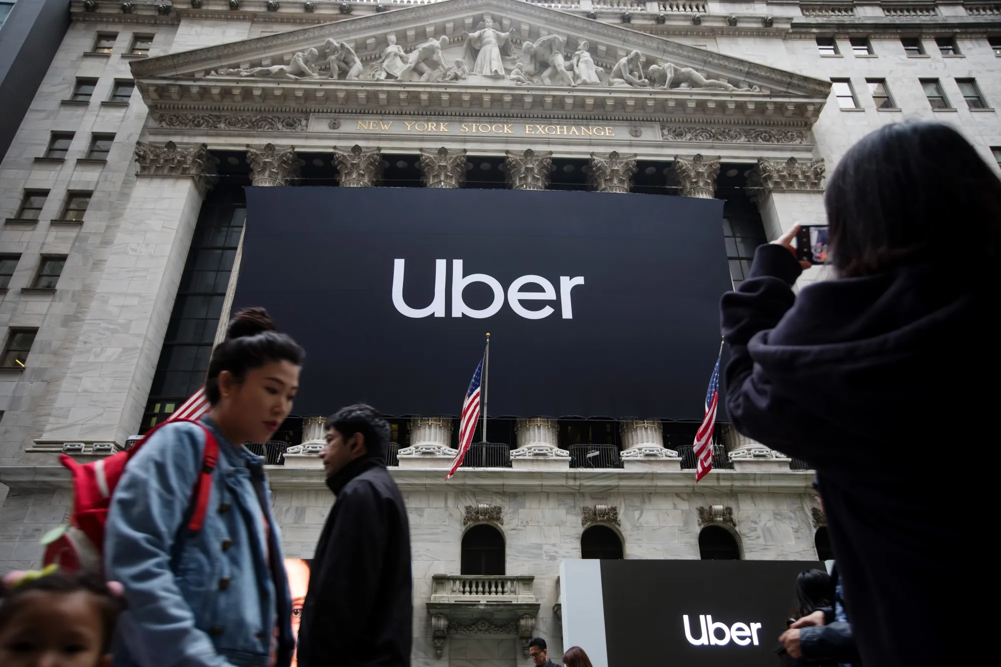 Pedestrians pass in front of the New York Stock Exchange&nbsp;during Uber’s IPO&nbsp;on May 10.