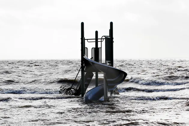 A playground slide is surrounded by water pushed up by Hurricane Sandy in Bellport, N.Y., on Oct. 30