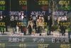 Pedestrians are reflected in a quotation board of the Tokyo Stock Exchange in Tokyo on April 8, 2020. 