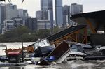 Boats and other debris are seen washed into the Milton ferry terminal on the Brisbane River in Brisbane, Australia, Monday, Feb. 28, 2022. Heavy rain is bringing record flooding to some east coast areas and claimed seven lives while the flooding in Brisbane, a population of 2.6 million, and its surrounds is the worst since 2011 when the city was inundated by what was described as a once-in-a-century event. (Darren England/AAP Image via AP)