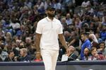 Los Angeles Lakers forward LeBron James walks the floor in street clothes during the first quarter of an NBA basketball game against the Dallas Mavericks in Dallas, Tuesday, March 29, 2022. (AP Photo/LM Otero)