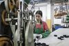 A workers handles a caster wheel at a factory operated in Foshan, China.