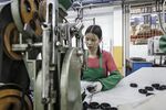 A workers handles a caster wheel at a factory operated in Foshan, China.