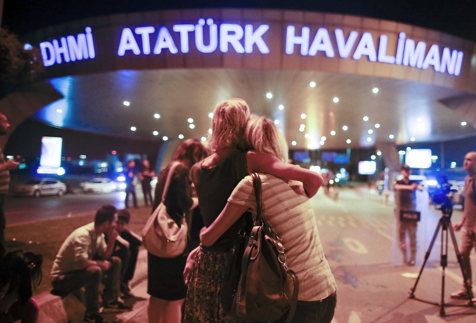 Passengers embrace at the entrance to Istanbul's Ataturk airport following their evacuation after a blast. 