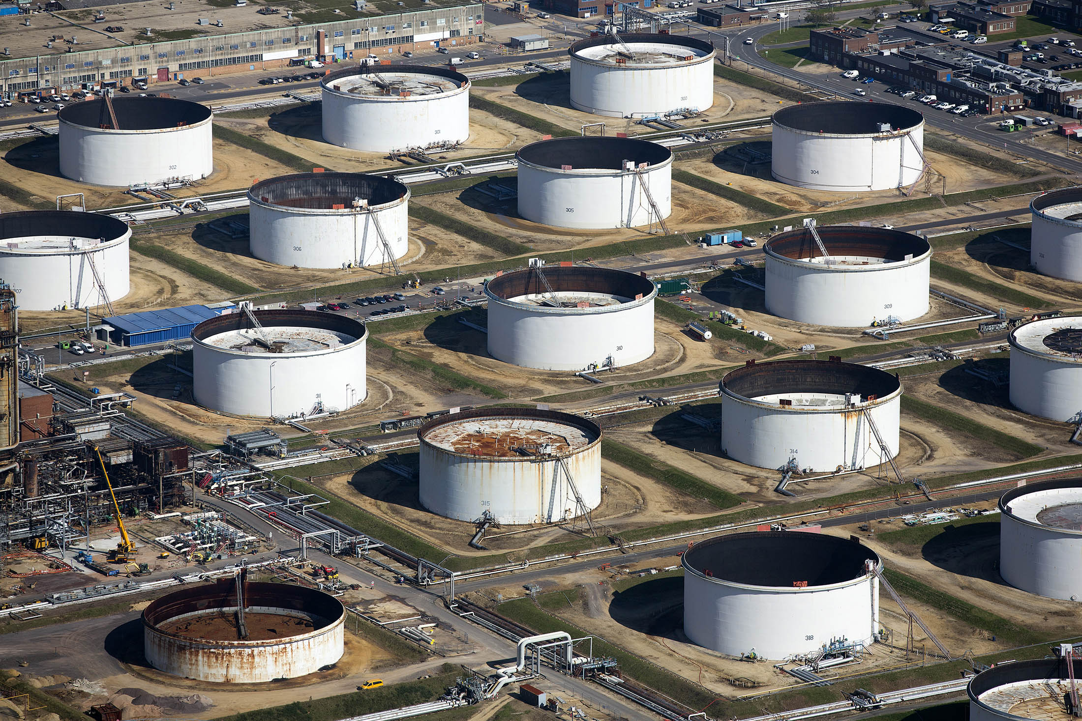Oil storage tanks sit at the Esso oil refinery, operated by Exxon Mobil Corp. in Fawley, U.K., on Friday, Oct. 2, 2015. A 50 percent drop in crude prices in the past year has hit earnings for oil and gas producers, forcing them to slash capital spending and scale back unprofitable operations.
