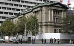 Pedestrians cross a road in front of the Bank of Japan (BOJ) headquarters in Tokyo, Japan.