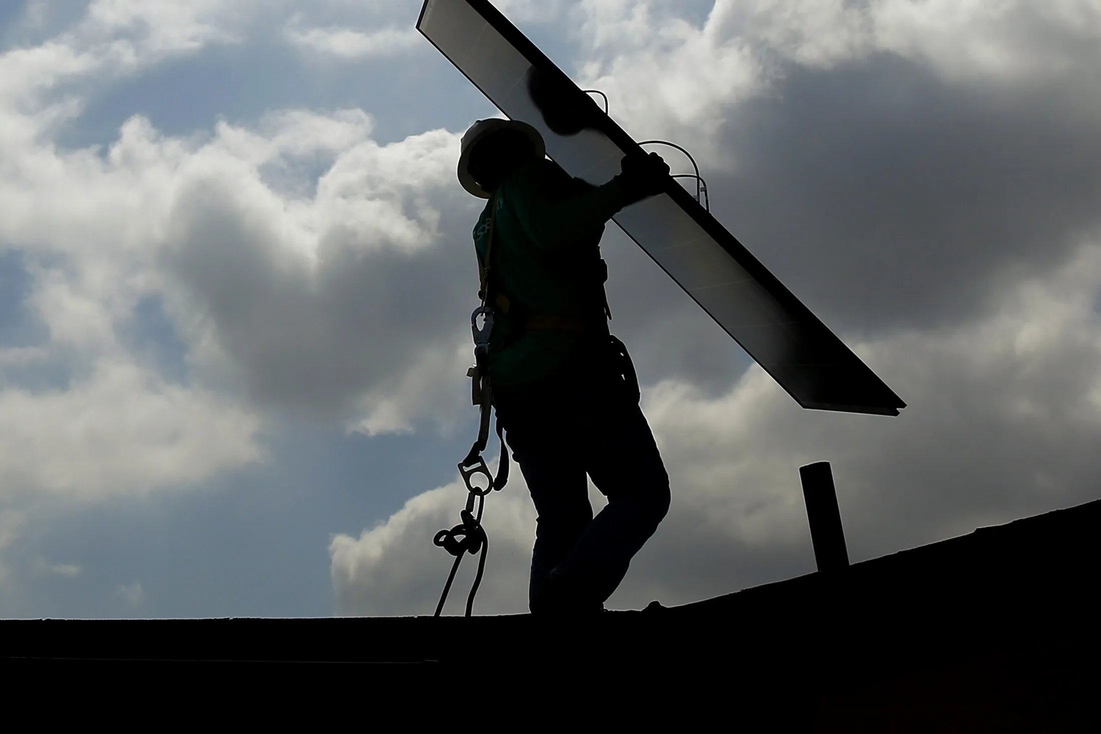 A SolarCity Corp. employee carries a solar panel during an installation at a home in Los Angeles, California.