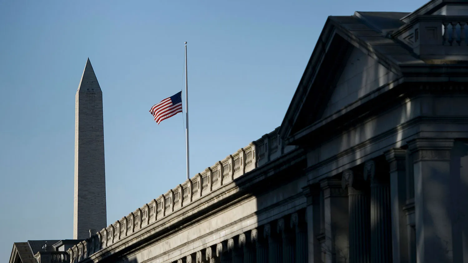 The Washington Monument and Treasury Department are seen with a flag at half staff on Feb. 18, 2016, in Washington.

