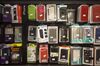 Smartphone cases hang on display inside an Orange SA mobile phone store in Marseille, France, on Tuesday, Dec. 22, 2015. Orange is in early talks about buying Bouygues SA's phone and television businesses, according to people familiar with the matter, in a move that would reduce the number of wireless carriers in France and follow in rivals' footsteps of bringing telecommunications and media together.