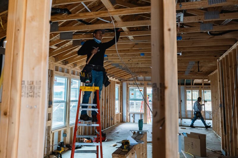 Workers install electrical wiring in a home under construction in Kyle, Texas, US