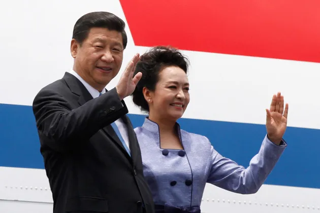 China's President Xi Jinping and his wife Peng Liyuan wave upon their arrival to the Benito Juarez International Airport in Mexico City, on June 4, 2013
