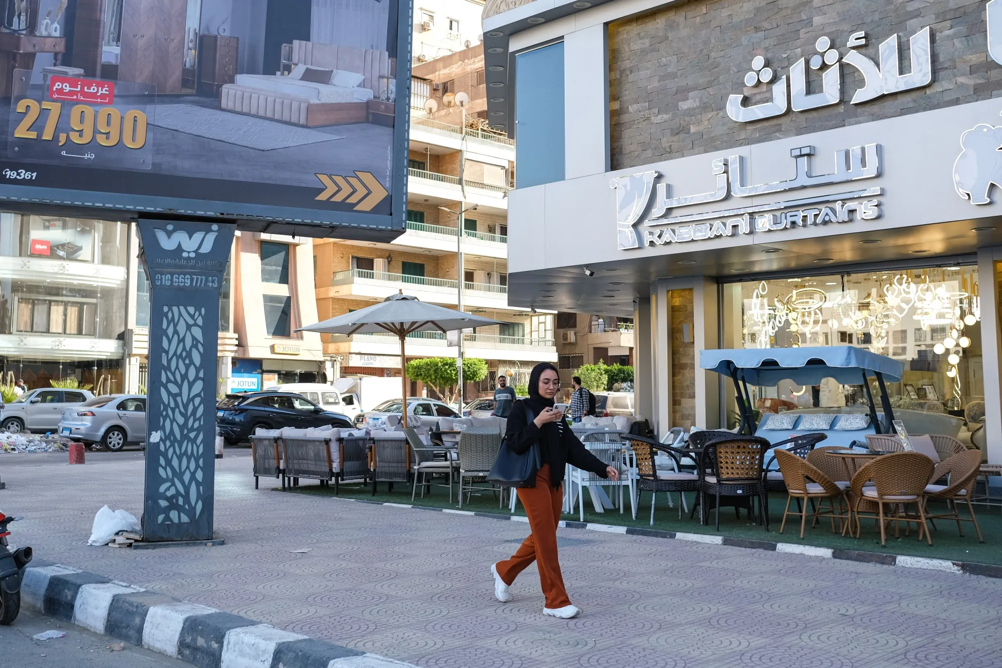 A pedestrian passes a furniture store in the Nasr City district of Cairo.&nbsp;Consumer price-growth slowed for a second month as Egypt cut interest rates.