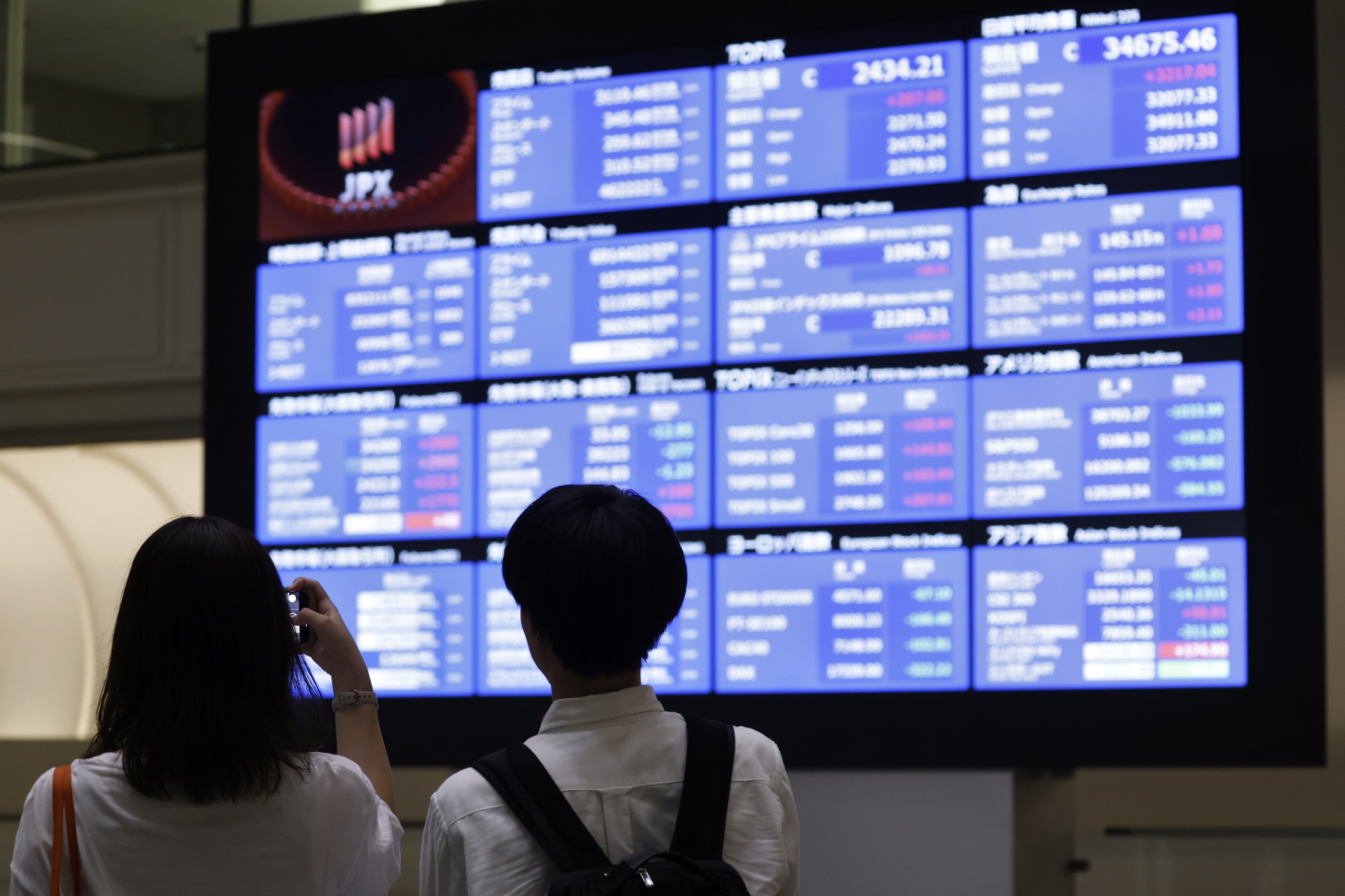 Visitors in front of an electric stock board at the Tokyo Stock Exchange (TSE) in Tokyo, Japan, on Tuesday, Aug. 6, 2024. 