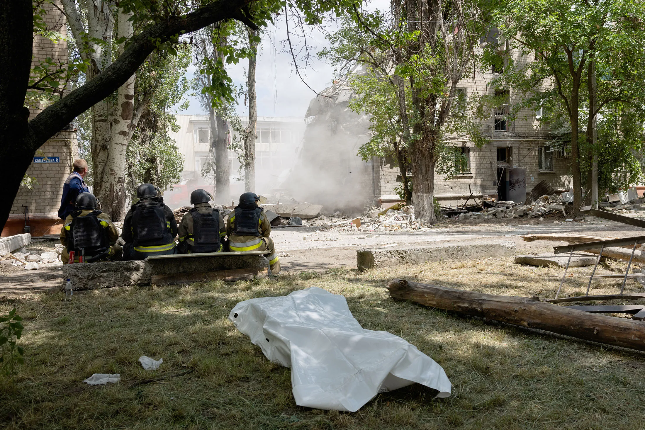 Rescuers rest amid damage&nbsp;following a Russian strike in Kramatorsk, Ukraine, on June 22.