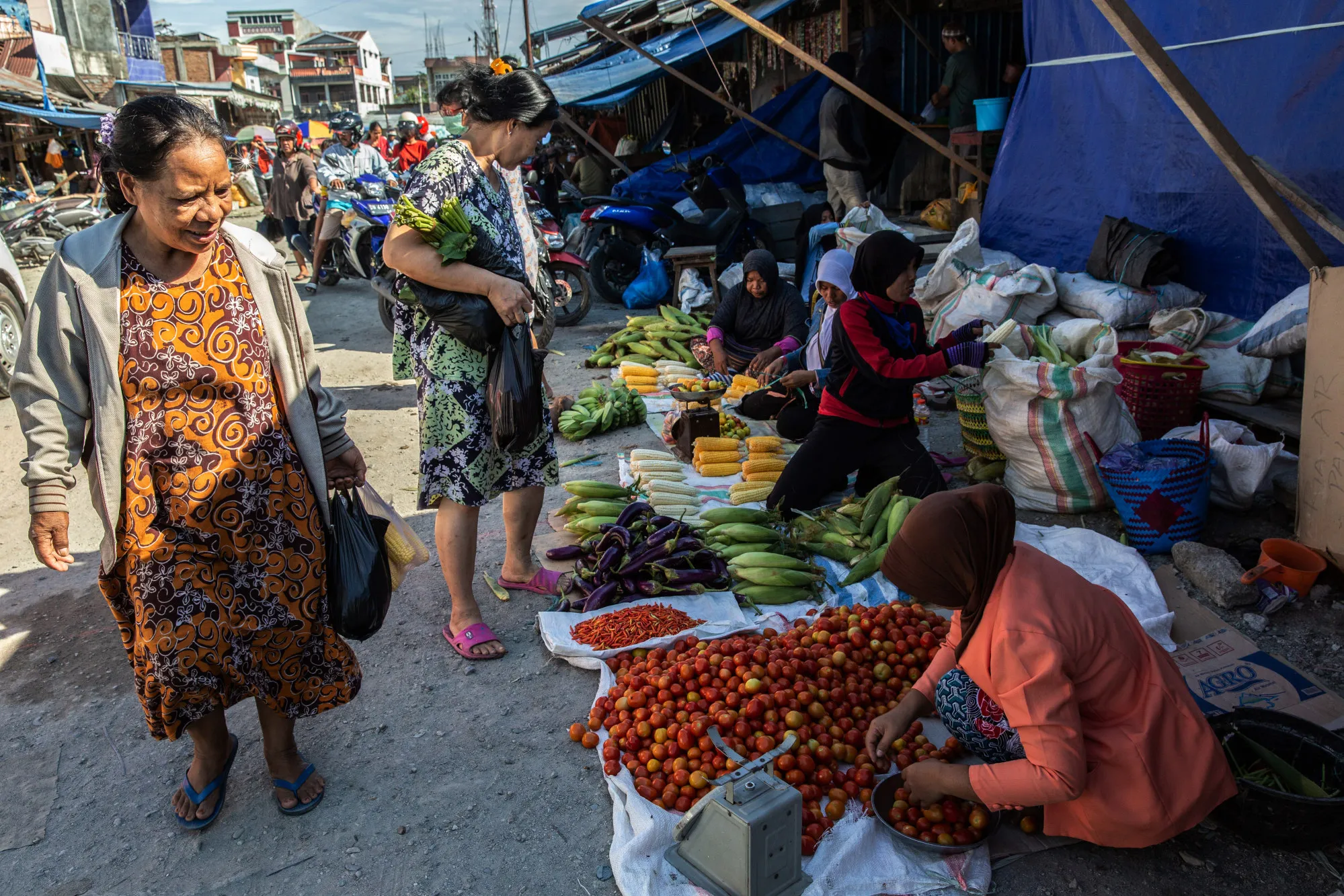 Customers walk past vegetable stalls at the Masomba traditional market in Palu, Central Sulawesi, Indonesia.