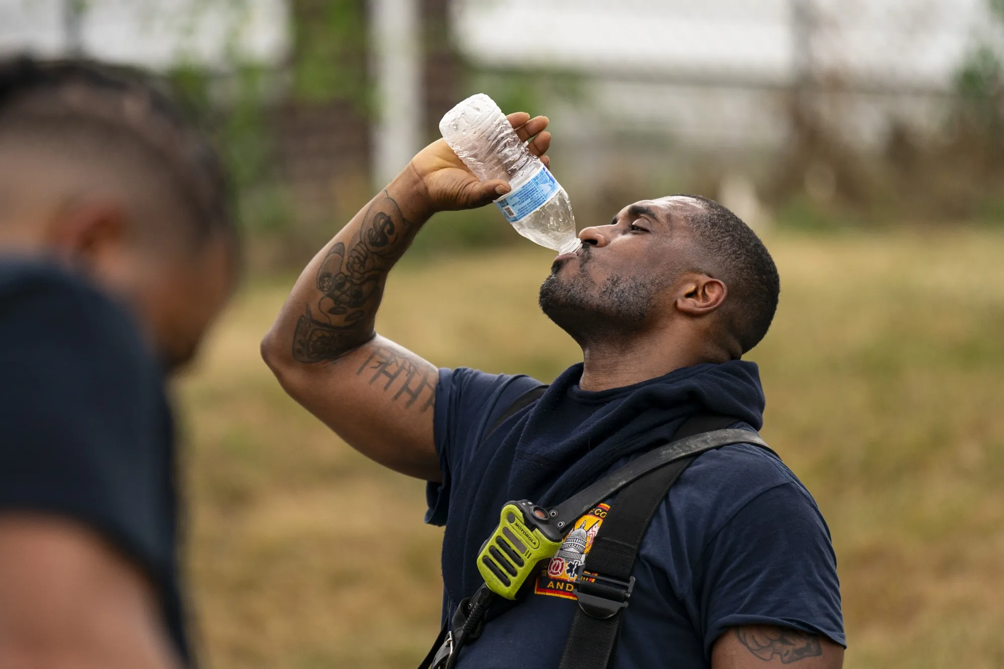 A firefighter drinks water following a kitchen fire during high temperatures in Washington, DC in June 2024.