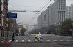 An epidemic control worker rides a bike across a nearly empty street near the Beijing’s Central Business District on Nov. 24. 