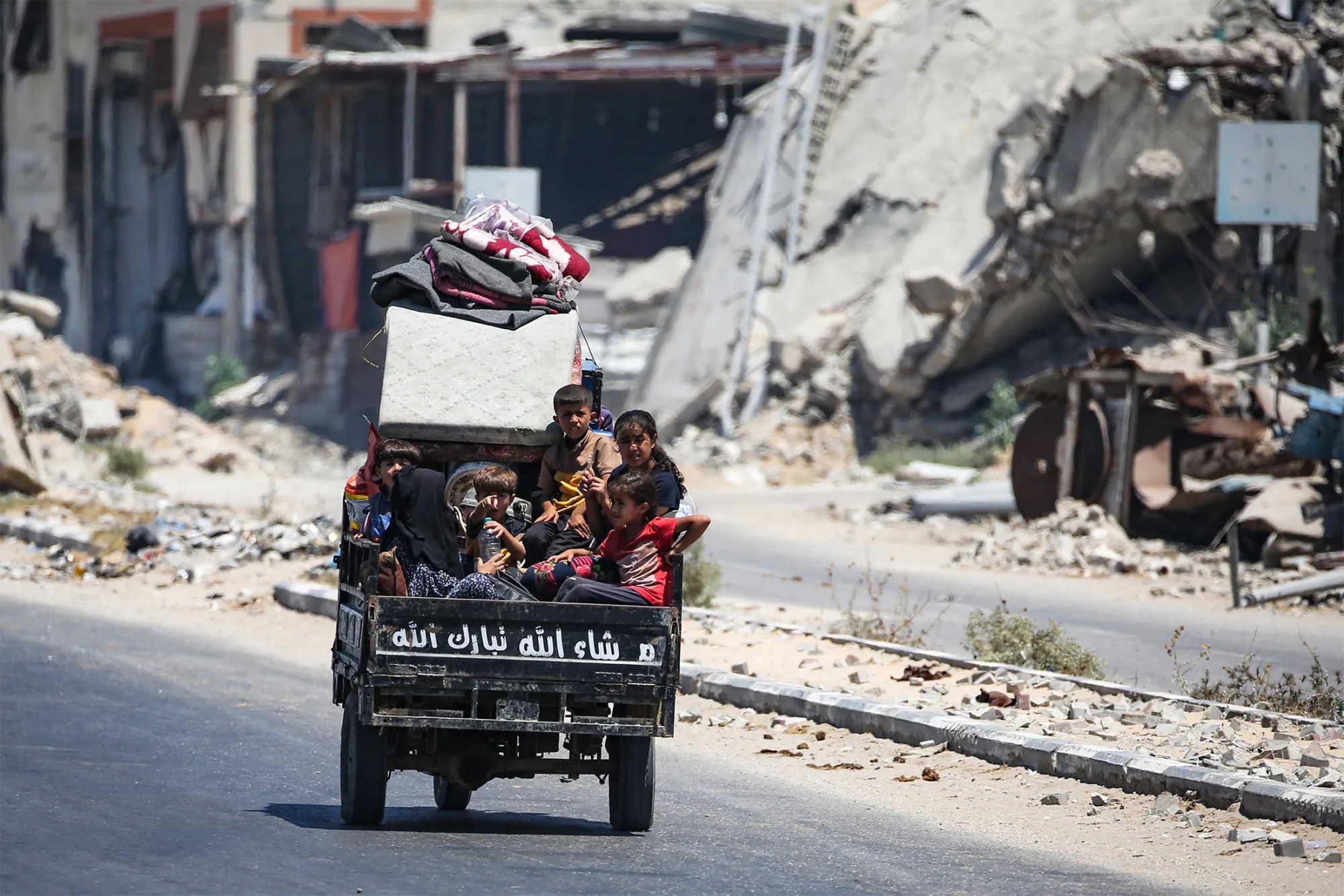 Children sit in the back of a vehicle as people flee with their belongings&nbsp;in the central Gaza Strip on Aug. 16.