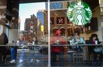 Customers sit inside a Starbucks corp. location in New York.