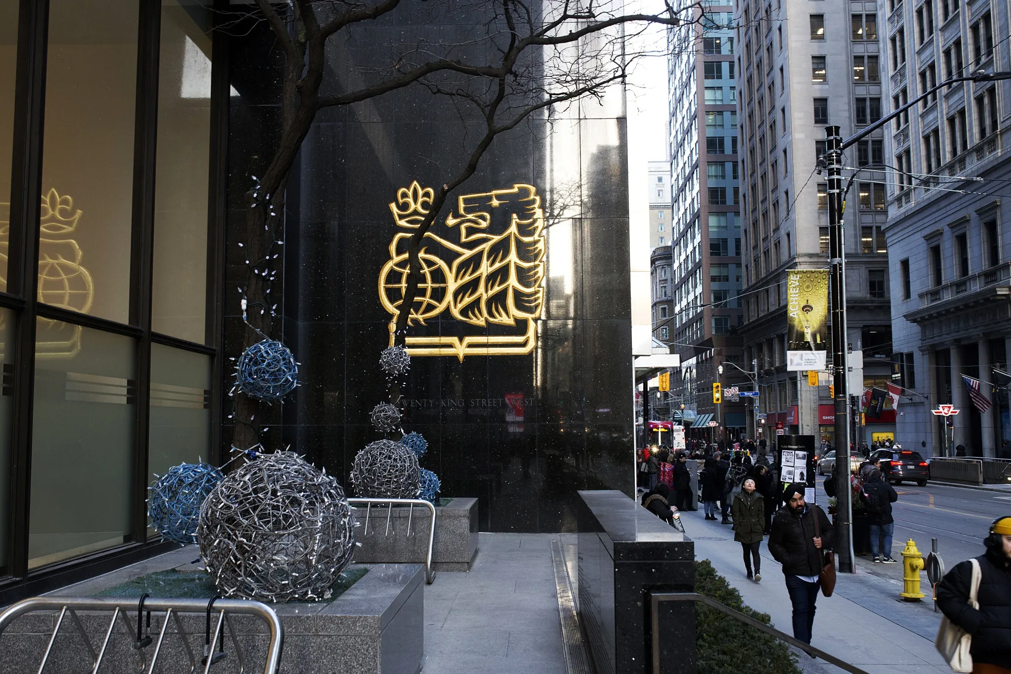 Pedestrians walk past Royal Bank of Canada headquarters in Toronto.