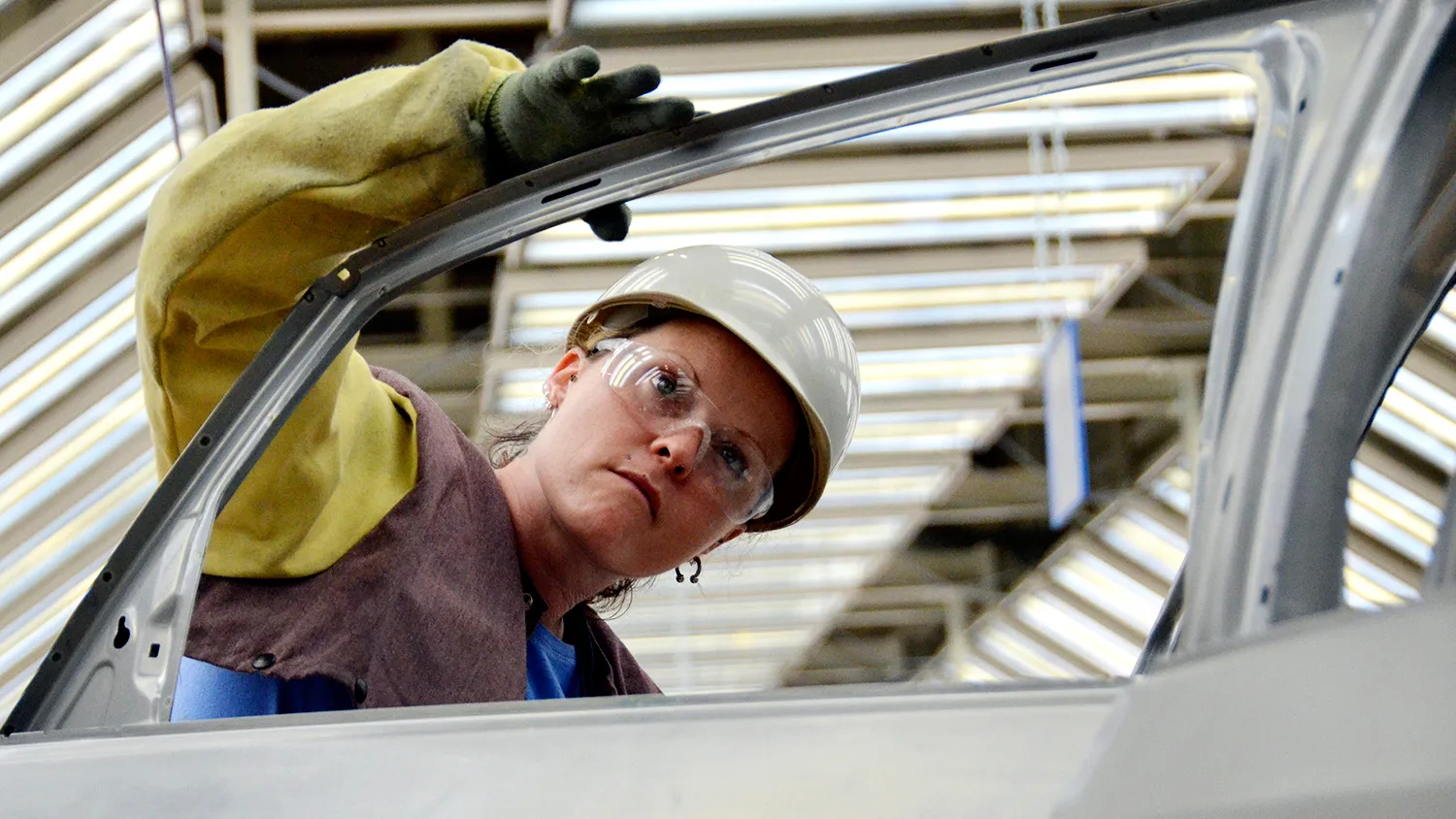 Amy LaLonde, a metal finishing body technician, inspects a 2012 Volkswagen Passat in the body shop at Volkswagen AG's factory in Chattanooga, Tennessee, on June 1, 2011.

